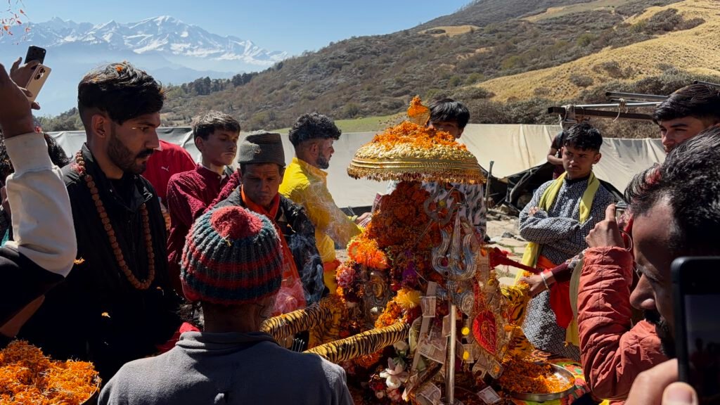 Pilgrims gathered around the decorated Panch Kedar doli with Himalayan peaks behind
