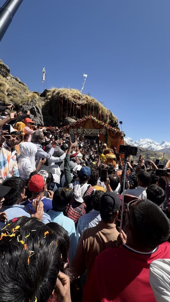 Pilgrims gathered at the flower-decorated Rudranath shrine with snow peaks beyond
